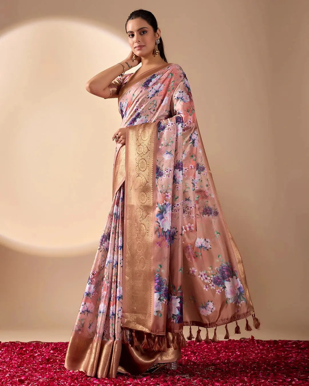 Soft pink lichi silk saree featuring a vibrant floral digital print, an elegant gold zari woven border, and tassel details by Kalyanja.